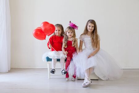 Girls with red heart-shaped balloons on birthday partyの写真素材