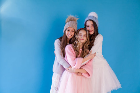Three beautiful fashionable girls in winter snow caps