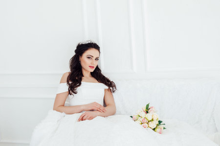 bride in wedding dress sitting on a sofa in White Hall wedding bouquetの写真素材
