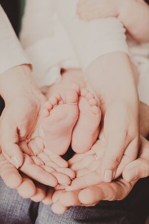 mom and dad are holding baby legsの写真素材