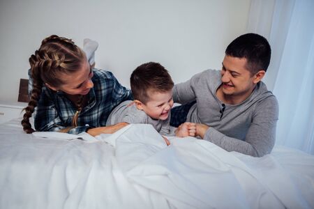 mom and dad and little boy in the bedroomの写真素材