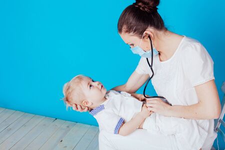 the doctor listens to the little boy stethoscopeの写真素材