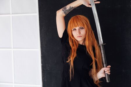 woman anime with red hair with Japanese samurai swordの写真素材