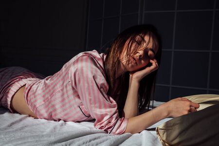 beautiful woman in pink Pajamas in the bedroomの写真素材