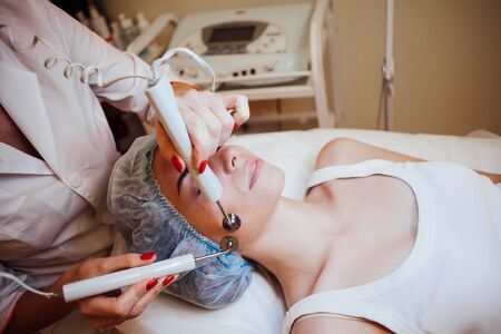 the doctor makes a woman patient procedures esthetician on face Spaの写真素材