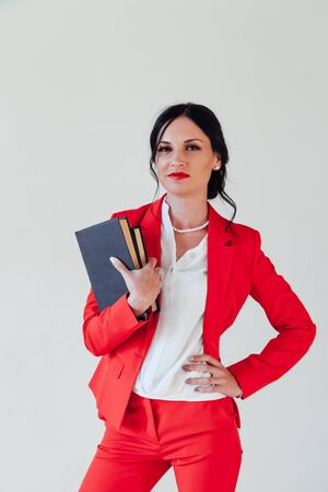 Portrait of a beautiful business woman brunette with in a red business suitの写真素材