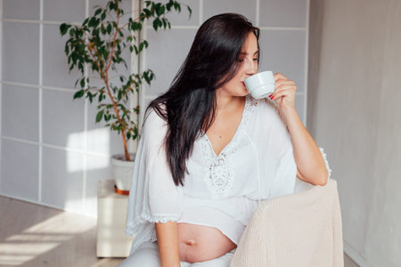 Portrait of a pregnant woman drinks