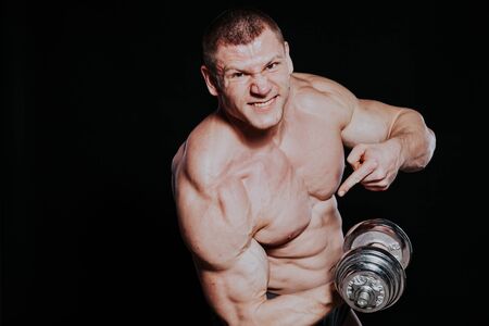 Sport the athlete bodybuilder build muscles dumbbellsの写真素材