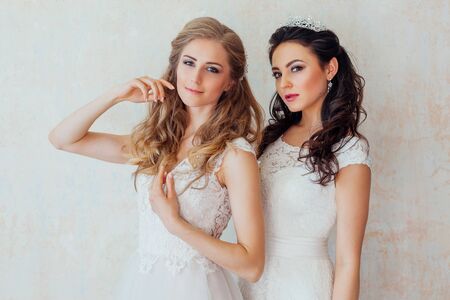 two girls in white dresses brunette and blondeの写真素材