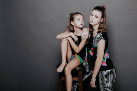 two fashionable girls sisters in beautiful clothes portraitの写真素材