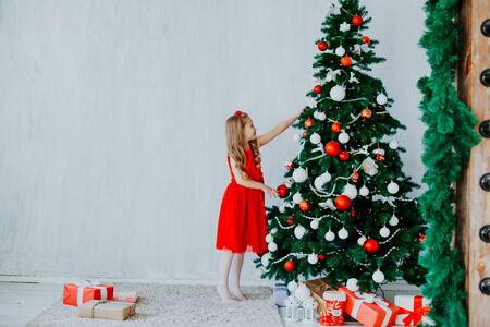 Christmas party girl with presents new year Christmas tree on a grey background giftsの写真素材