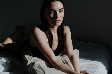 beautiful woman in underwear in the bedroom on the bed in the morningの写真素材