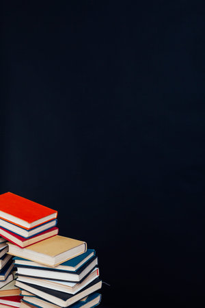 many of educational books for learning preparation for college exams on a black background