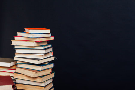 many of educational books for learning preparation for college exams on a black background