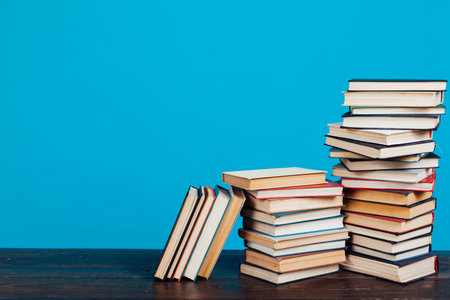 many of educational books for learning preparation for college exams on a blue background