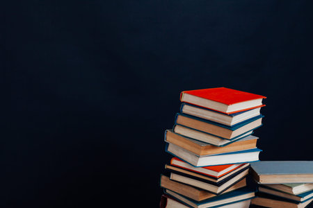 many of educational books for learning preparation for college exams on a black background