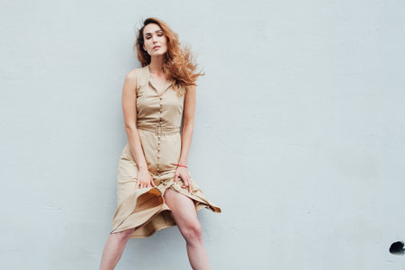 Portrait of a beautiful fashionable woman in a beige dress for a walk