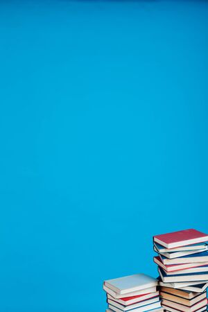 a lot of stacks of educational books in the college library on a blue backgroundの写真素材