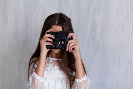 girl photographer with camera on grey backgroundの写真素材