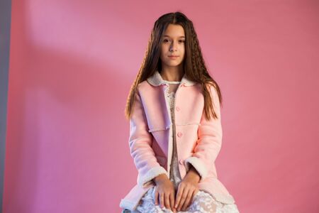 portrait of a beautiful fashionable girl in white pink clothesの写真素材