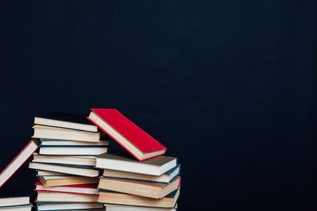 lots of stacks of educational books to teach at the college library on a black backgroundの写真素材