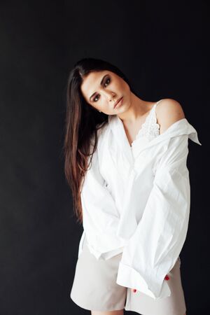 Portrait of a beautiful fashionable oriental brunette woman in a white shirt and shortsの写真素材