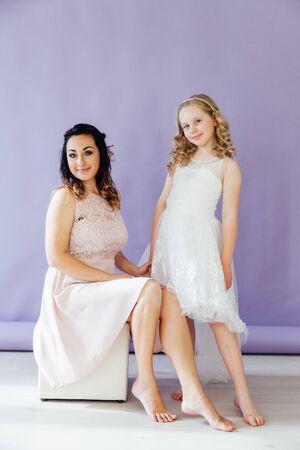 beautiful mom and daughter in white dresses in close familyの写真素材