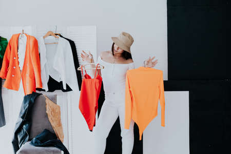 Beautiful woman looks things up at fitting in wardrobeの写真素材