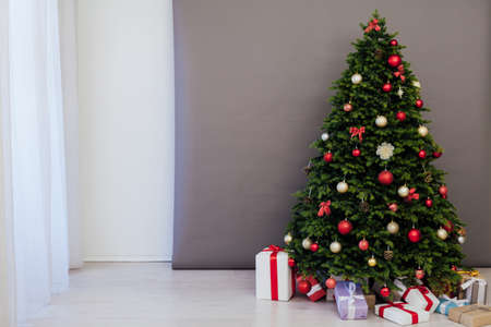 The interior of the room is a green Christmas tree with red gifts for the new year decor of the winter holiday homeの写真素材