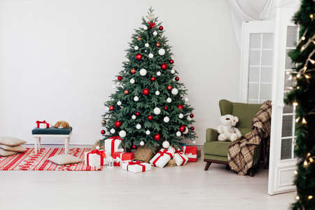Blue Christmas tree with gifts decor for the new year winter in the white roomの写真素材