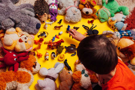 lots of baby soft toys for developing games on a yellow backgroundの写真素材