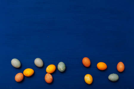 lots of eggs of different colors on Easter holiday on a blue backgroundの写真素材