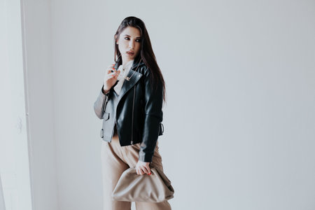 Portrait of a beautiful fashionable oriental brunette woman in a black leather jacket