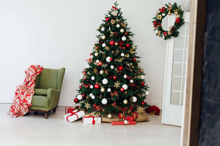Christmas tree with gifts for the new year in the interior of the white roomの写真素材