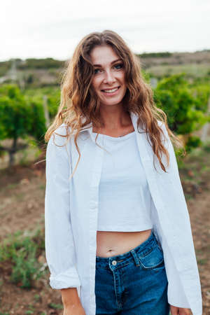 Beautiful woman walks on a picnic in the vineyardの写真素材