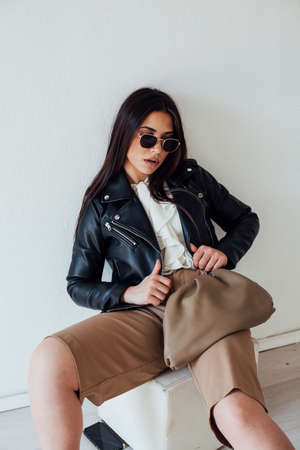 Beautiful fashionable brunette woman in a black leather jacketの写真素材