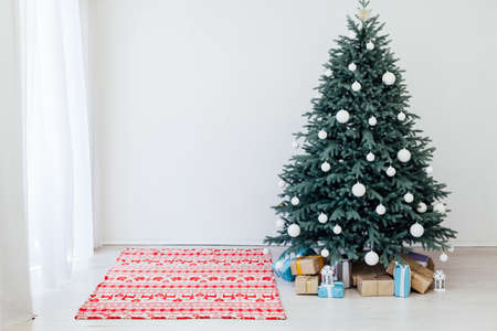 New Years Christmas Tree with gifts and decor garlands interiorの写真素材
