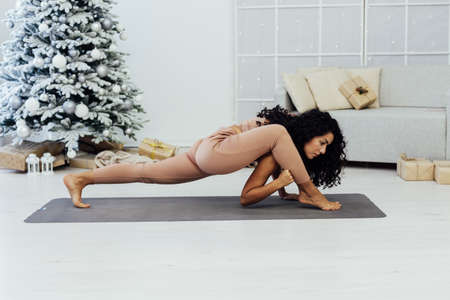 Beautiful woman yoga fitness gymnastics asana at christmas treeの写真素材