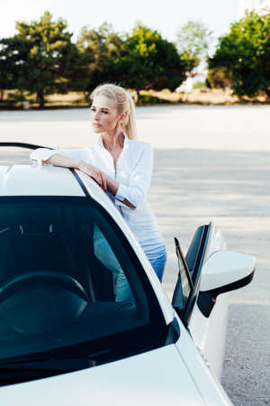 Beautiful female blonde driver behind the wheel of a sports carの写真素材