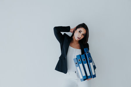 Beautiful business woman in business suit at work in the office with folders for papers