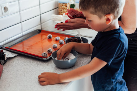 woman and son cook sweet cakes in the kitchen
