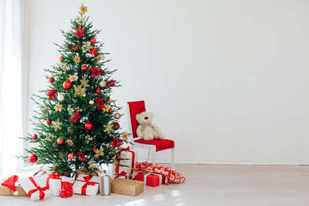 Big beautiful christmas tree decorated with beautiful shiny baubles and many different presents on wooden floor.の写真素材