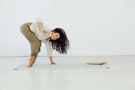 Brunette woman engaged in yoga asana gymnastics flexibility bodyの写真素材