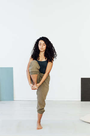 Brunette woman engaged in yoga asana gymnastics fitness flexibility body sportの写真素材