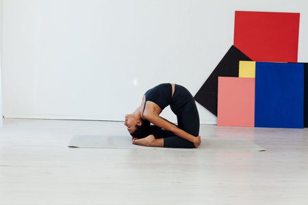 Beautiful brunette woman engaged in yoga asana gymnastics fitness flexibility body