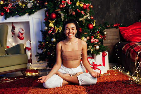 Beautiful woman yoga Christmas tree with new year giftsの写真素材