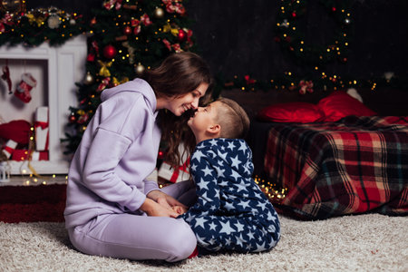 Mom and son at Christmas tree lights garland gifts new yearの写真素材
