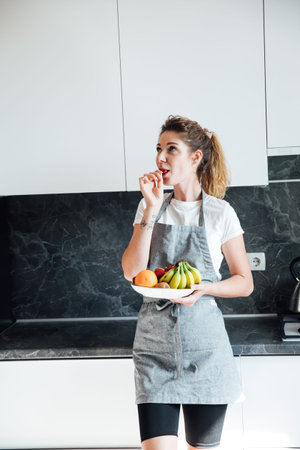 woman housewife eats fruit and cooks food in the kitchen