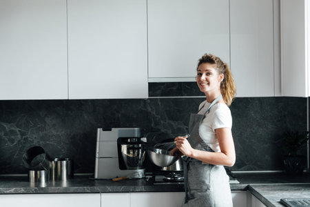 beautiful woman housewife cooks delicious food in the kitchen