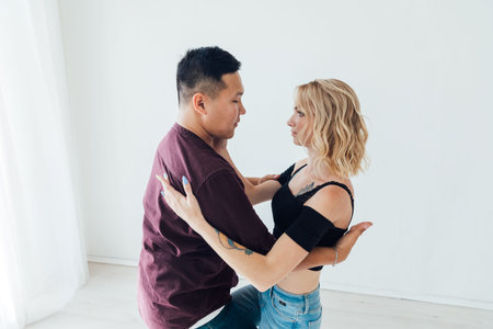 a man and a woman dance bachata to music in a white room